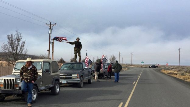 Les gens ondulent des drapeaux des USA près du refuge de Malheur